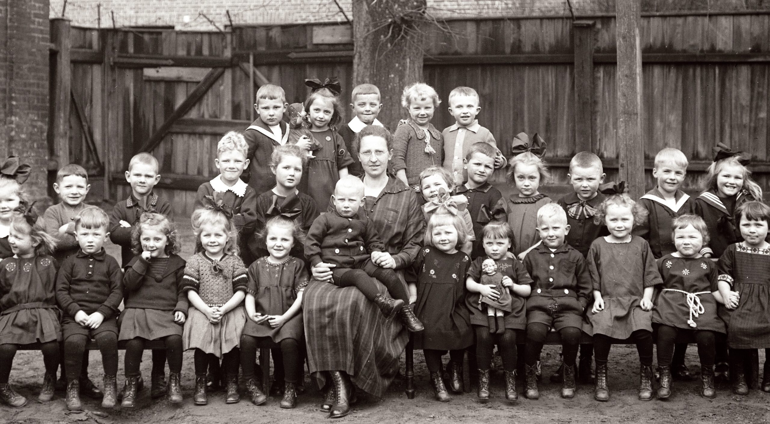 Schwarz-weiß Aufnahme, Kindergartengruppe mit Kindergärtnerin.