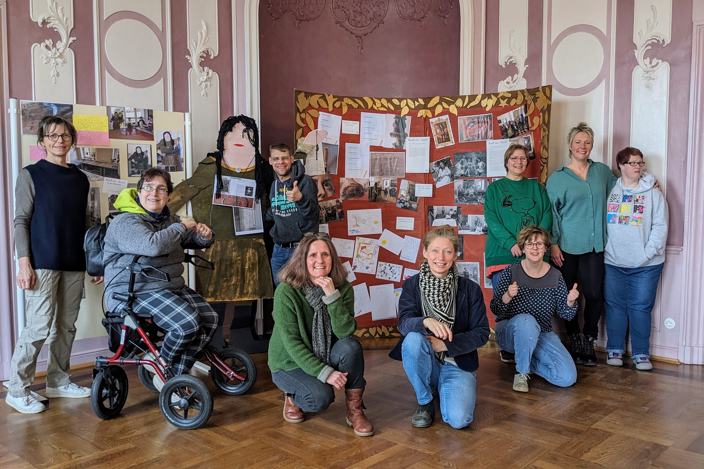 Gruppenfoto mit Teilnehmer*innen eines inklusiven Workshops vor ihrer selbstgemachten Fotowand im Museum.